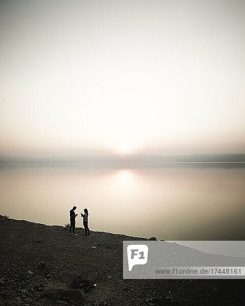 Couple in front of the see in sunset
