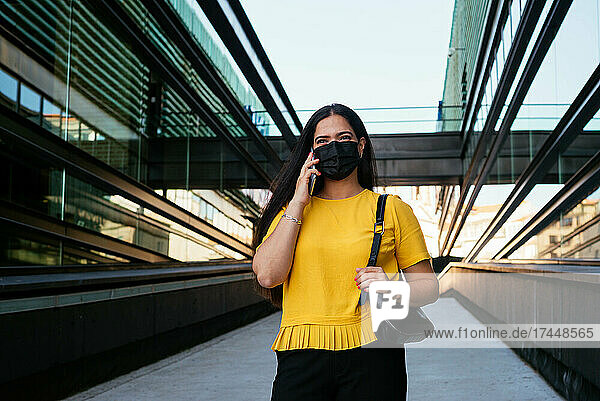 Woman talking on the phone in front of a corporate building