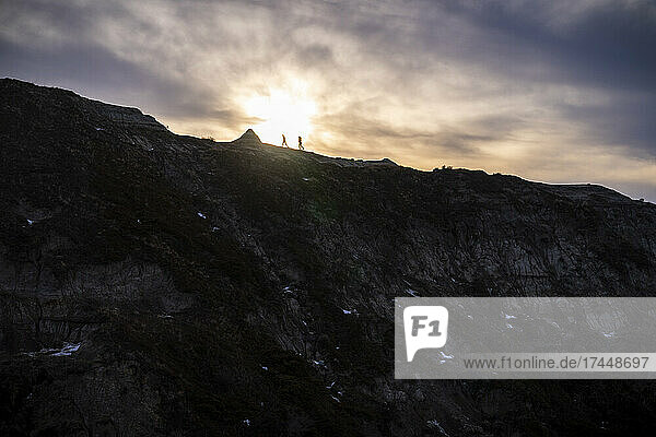 Silhouette Of Trail Running Duo In Alberta Badlands