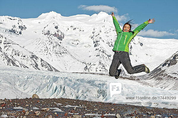 Woman jumping at Svinafellsjokull glacier at Skaftafell / Iceland