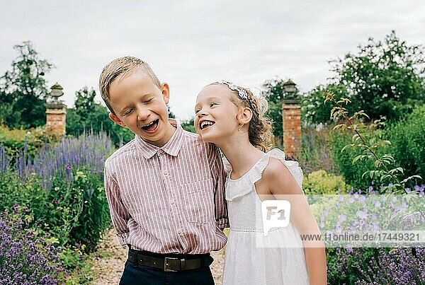 Boy and girl laughing happily in a beautiful flower field