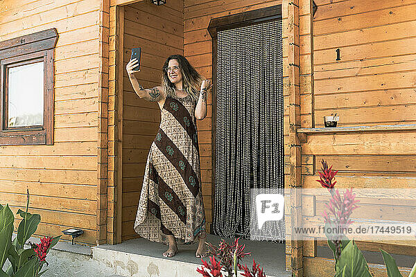 woman using a phone while spending time in her cabin in the woods