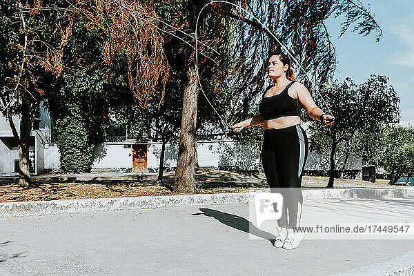 young Latin plus size woman jumping the rope in park in Mexico