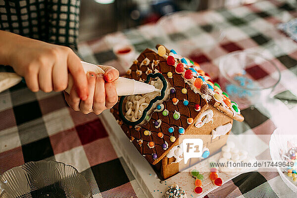 close up of gingerbread house being decorated
