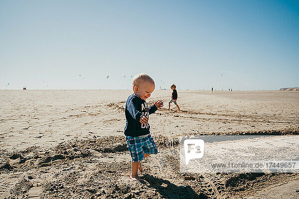 Young boy running happy at kiters beach in Fuerteventura