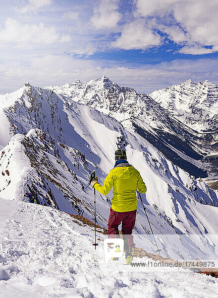 Man Hiking On Summit Mountain Peak In Epic Extreme Winter Landscape