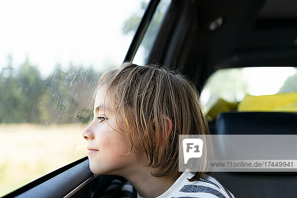 Boy looking out the window of car on a road trip