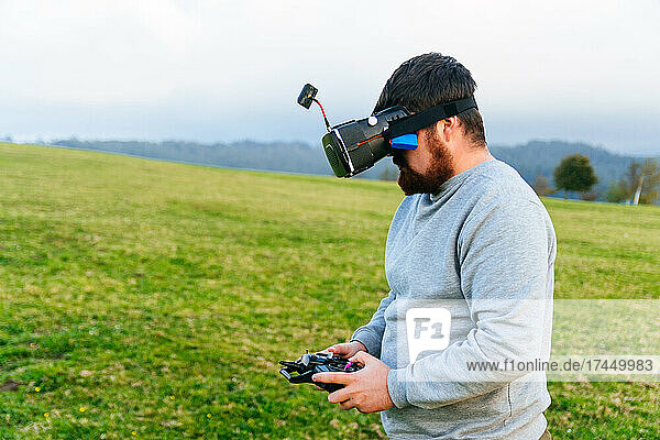 Man using a drone with remote controller wearing vr