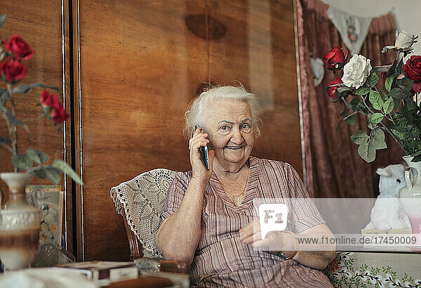 portrait of elderly lady in her home while telephoning