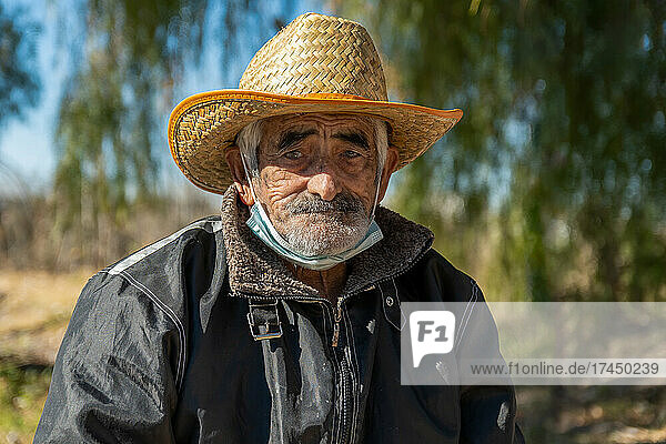 Close-up of Latin American grandfather with hat.