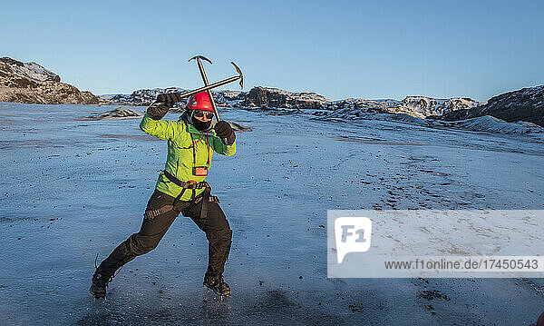woman posing with ice pick on glacier in Iceland