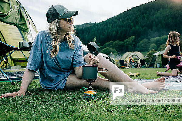 woman sat with a portable stove whilst camping in Snowdonia