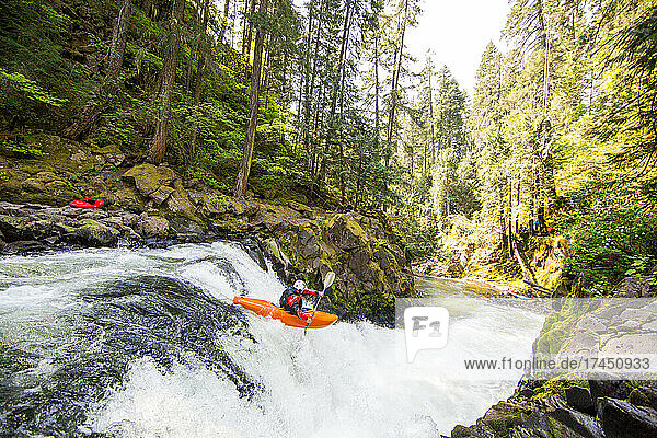 Man kayaks off a waterfall