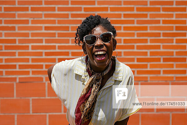 Trendy black female laughing on street