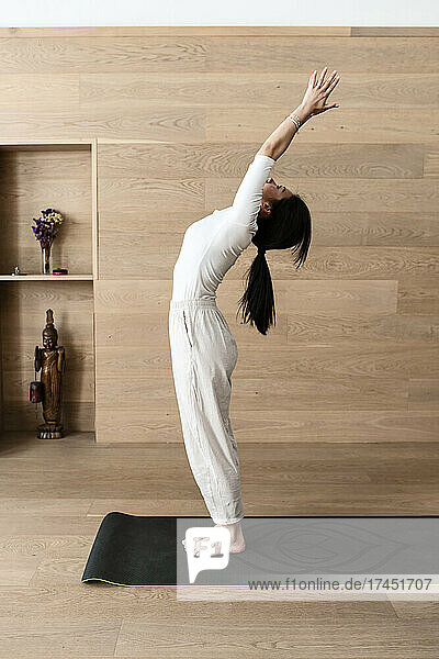 A woman practicing yoga performs back bend  Hasta Uttanasana pose