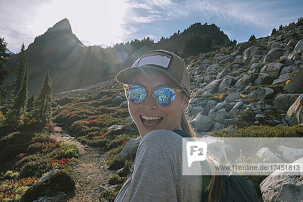 Closeup Of Happy Female Hiker With Sunglasses On Looking at Camera