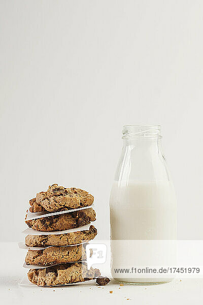 Stack of cookies beside bottle of milk