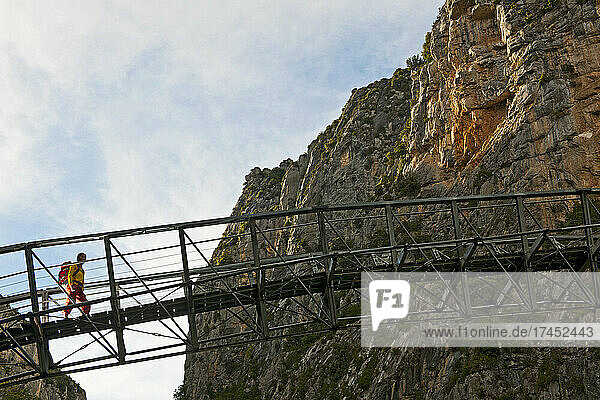 female hiker crossing steal bridge in the Verdon canyon