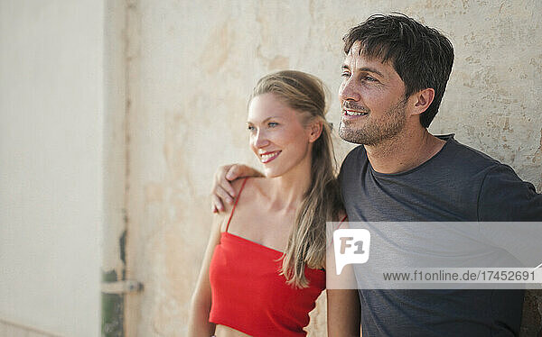 portrait of a young couple leaning against a wall