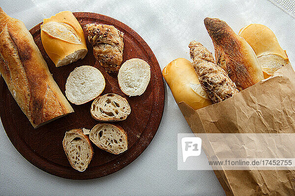 rye  wheat  multigrain baguettes paper bag  wooden board pieces