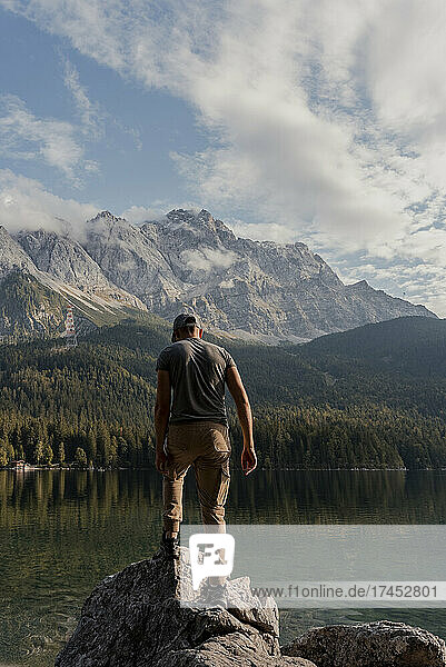 Man standing on a rock by lake