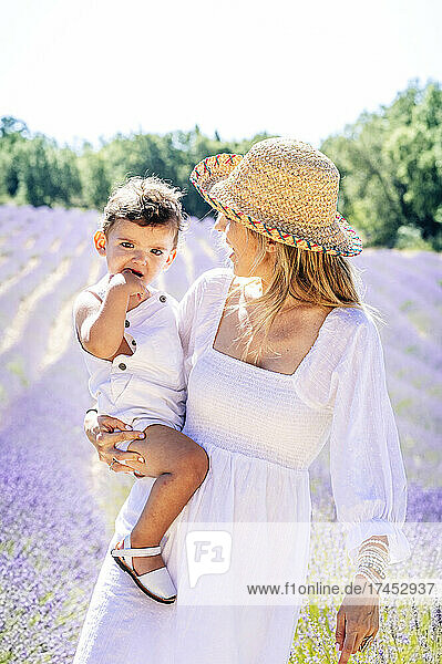 Mother holding her little son in front of lavender field