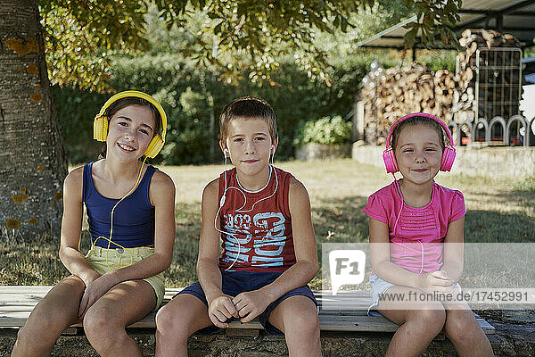 Three kids smile in front of the camera while they