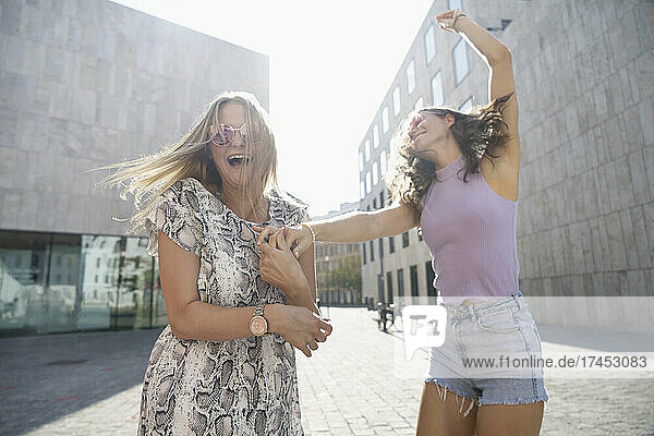 two young happy women dancing in the city of Munich