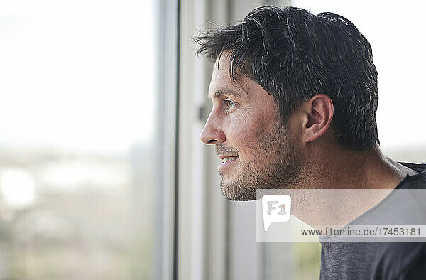 portrait of young man while looking out the window