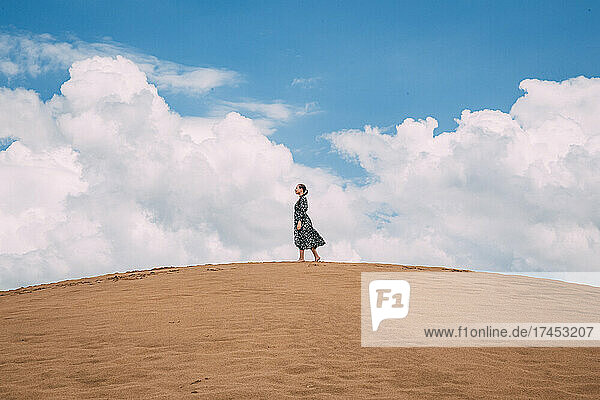Beautiful landscape in sand dunes. A girl walks