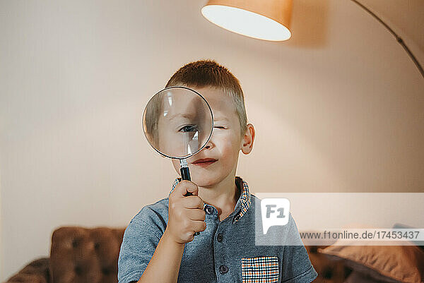 Cute little boy holding a magnifying glass