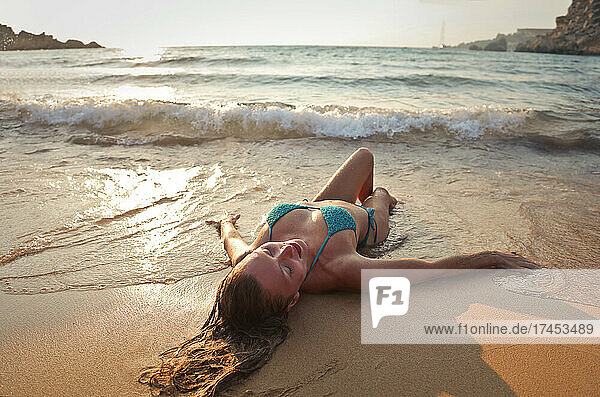 young woman lying on the beach