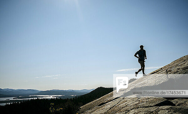 Man trail runs on mountain near rocky summit  Greenville Maine