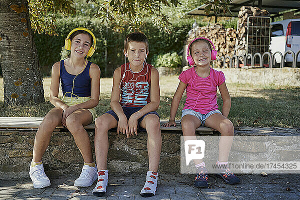 Three kids smile in front of the camera