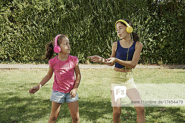 Two girls play at backyard while they wear a yellow