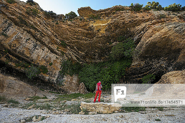 A women hiking a scenic trail under a giant overhang Caves of Zaen