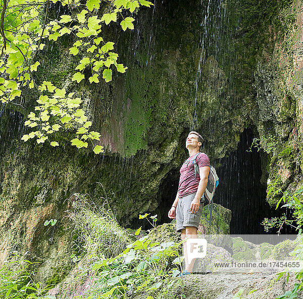 Adult man enjoys nature while hiking at Sipote waterfall  Transy