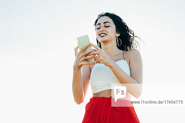 Young woman using smartphone at sunset
