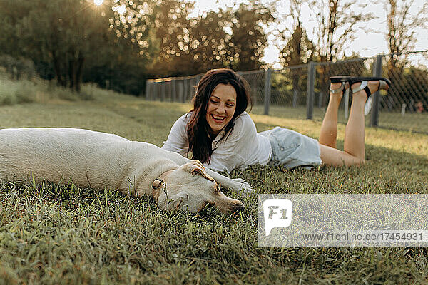 Happy woman hugging and having fun with her Labrador puppy outdoors.
