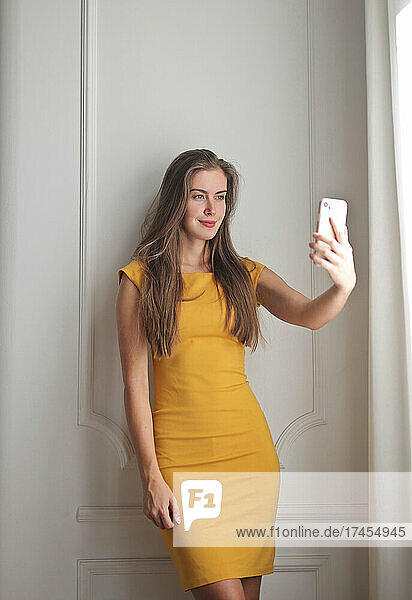young woman takes a selfie at home