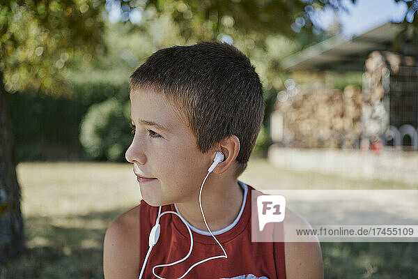 A cute boy listen to music while he looks away