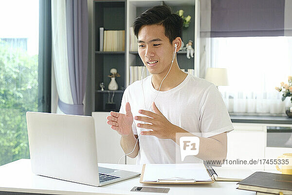 Young man working and studying online at home.