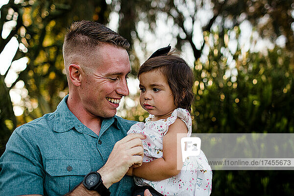 Close Up of Military Father Holding Young Daughter in San Diego