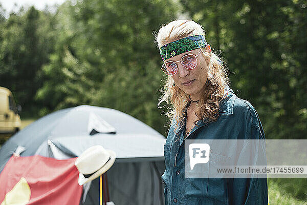 Bohemian hippy woman with Lennon glasses bandana festival camping