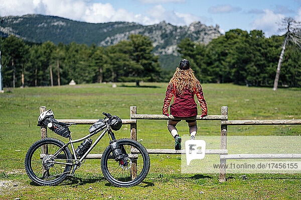 Woman enjoying with a mountain bike in nature  practices bikepacking