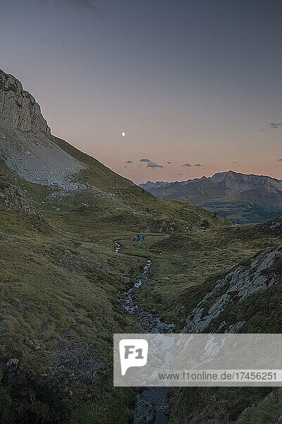 Group of people with tents watching sunset and moon rise  The Pyrenees