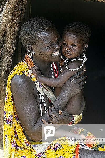Woman with her baby sitting in a hut  Toposa tribe  Eastern Equatoria  South Sudan  Africa