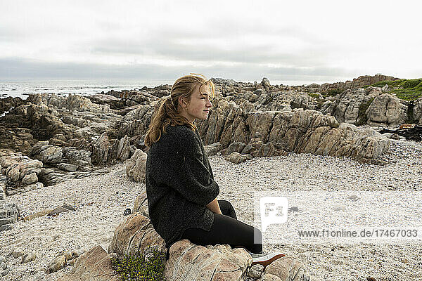 teenage girl exploring rocky cast of De Kelders  South Africa