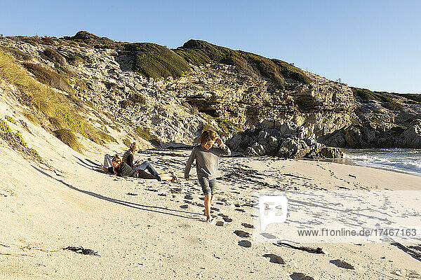 Familie an einem Sandstrand  Junge läuft durch weichen Sand
