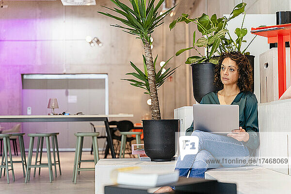 Businesswoman with laptop sitting in office